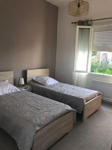 une chambre avec deux lits et une fenêtre dans l'établissement Maison 21, agréable maison de ville avec piscine, à Sommières