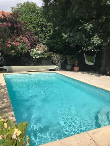 une grande piscine bleue dans une cour dans l'établissement Maison 21, agréable maison de ville avec piscine, à Sommières