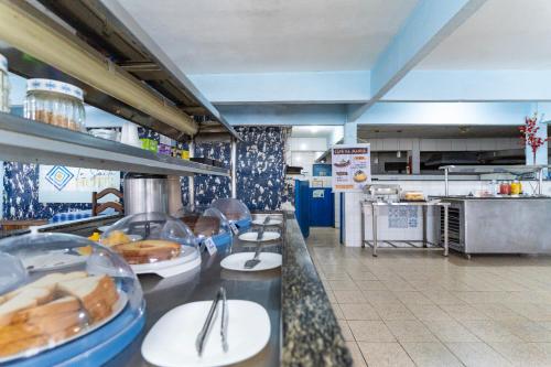 a fast food kitchen with a counter with plates of food at La Suite Praia Hotel in Caucaia