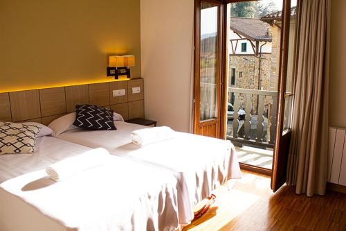 2 Betten in einem Zimmer mit einem großen Fenster in der Unterkunft Hotel valle de turtzioz in Trucios-Turtzioz