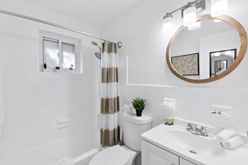a bathroom with a toilet and a sink and a mirror at Lake Ridge Villa - Free Parking in Fort Lauderdale