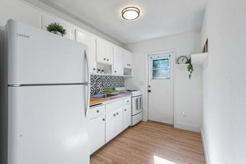a kitchen with white cabinets and a refrigerator at Lake Ridge Villa - Free Parking in Fort Lauderdale