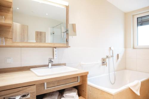 a bathroom with a sink and a bath tub at Hotel Krone in Mondsee