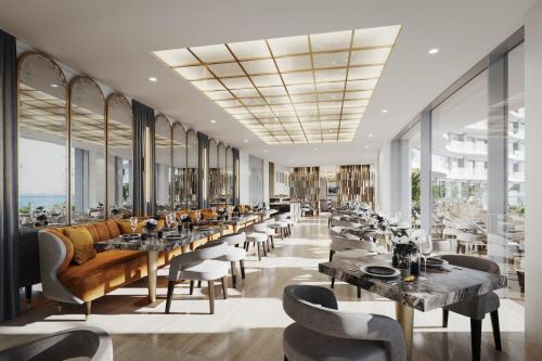 a restaurant with tables and chairs and windows at Del Mar Beachfront 3 Bedroom 'C' Residence in Limassol