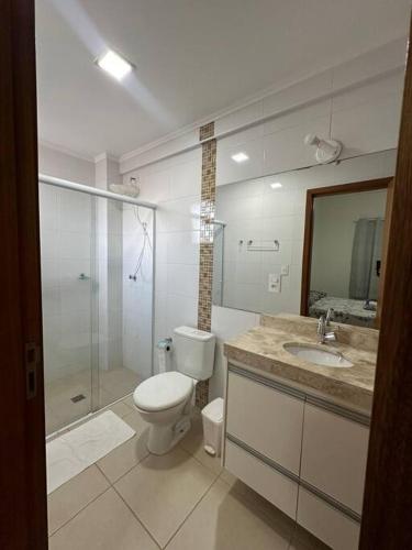 a bathroom with a toilet and a sink and a shower at Apto Apólo - 3 dorm Wifi in São Carlos