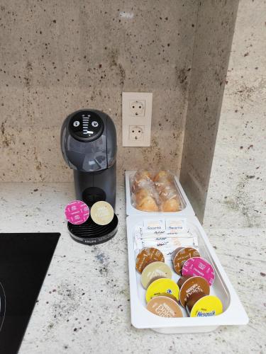 a box of donuts next to a coffee maker at Apartamentos Centro Oviedo Caveda in Oviedo