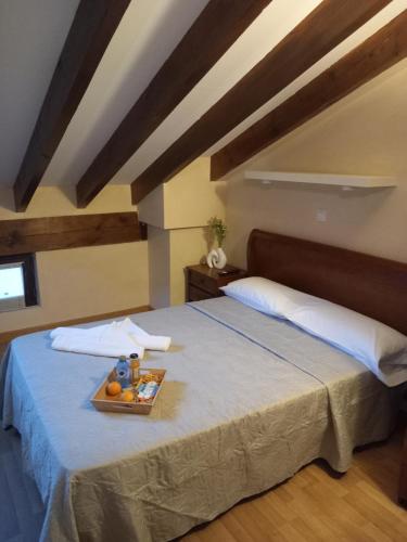 a bedroom with a bed with a tray of fruit on it at Hostería Río Negro in Bárcena de Cicero