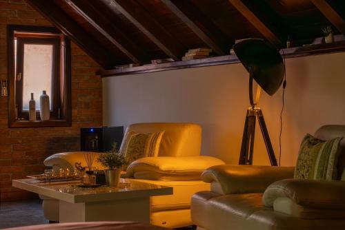 a living room with couches and a table and a lamp at Studio apartman & Wine House ONDINE in Zmajevac