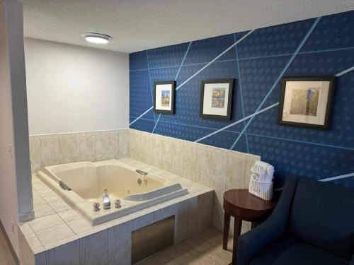 a bathroom with a tub and a blue wall at Comfort Inn Grand Junction I-70 in Grand Junction