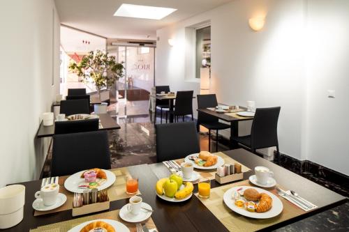 un comedor con una mesa con platos de comida en Hotel Rio Muralto en Locarno