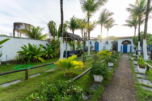 a garden with palm trees and a building at La Suite Praia Hotel in Caucaia