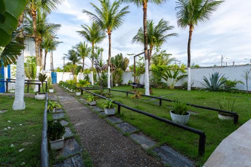 a garden with palm trees and a pathway at La Suite Praia Hotel in Caucaia