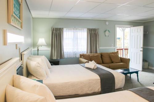 une chambre d'hôtel avec un lit et un canapé dans l'établissement The Janmere Motel, à Hampton Beach