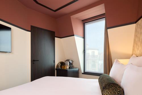 a hotel room with a bed and a window at Maison Cassandre in Paris