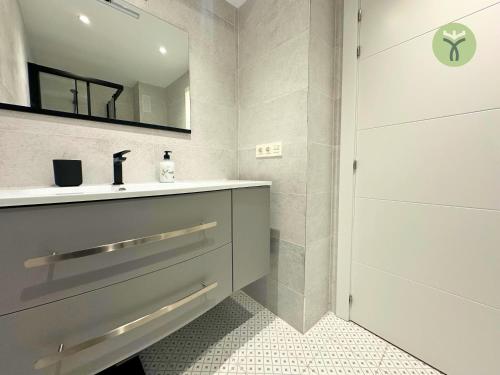 W łazience znajduje się umywalka i lustro. w obiekcie Dos Torres Mozart - Atardecer en Zaragoza w Saragossie