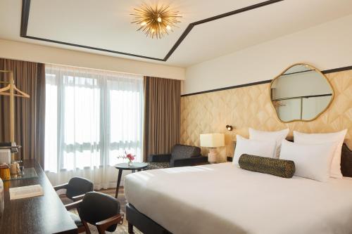 a hotel room with a large bed and a mirror at Maison Cassandre in Paris