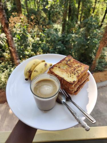- un plat avec du pain grillé et une tasse de café dans l'établissement Jungle valley Munnar, à Munnar