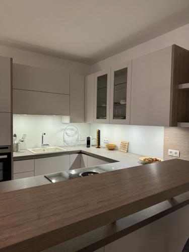 a kitchen with white cabinets and a wooden counter top at Wohlfühlen in Gänserndorf