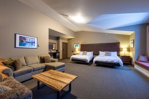 ein Hotelzimmer mit 2 Betten und einem Sofa in der Unterkunft Copper Horse Lodge in Golden