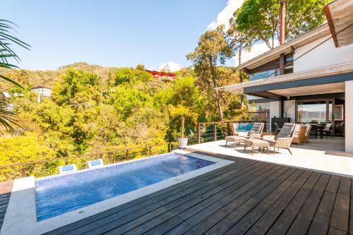 an outdoor deck with a swimming pool and a house at Hermosa Casa con Terraza y Vista al Lago en Avándaro in Valle de Bravo