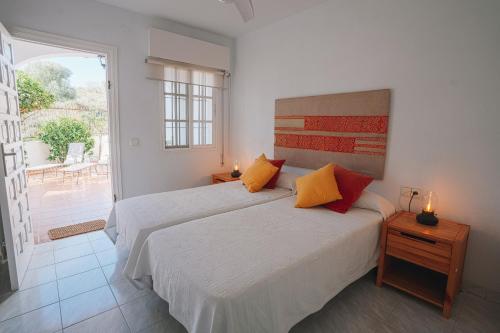 Un dormitorio blanco con dos camas y un balcón. en Villa Julia, ¡Beach, pool, sun and rest!, en Málaga