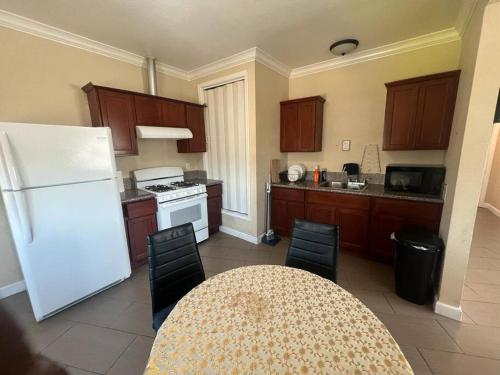 eine Küche mit einem weißen Kühlschrank und einem Tisch mit Stühlen in der Unterkunft Luxury apartment in Oakland in Oakland