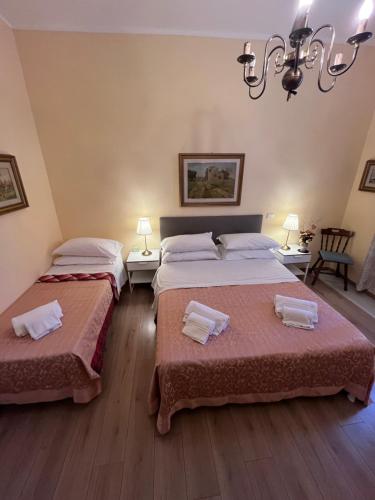 a bedroom with two beds and a chandelier at Villa Matilde in Pisa