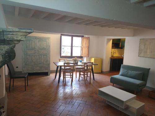 a living room with a table and chairs and a couch at Palazzo Reali Apartment - Camera nella storia di Pistoia in Pistoia