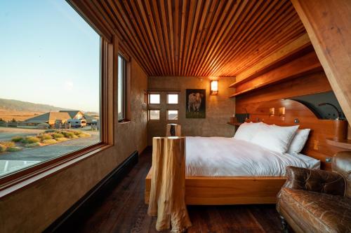 a bedroom with a bed and a large window at The Inn at Newport Ranch in Fort Bragg