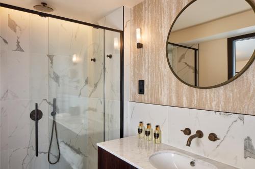 een badkamer met een douche, een wastafel en een spiegel bij Maison Cassandre in Parijs