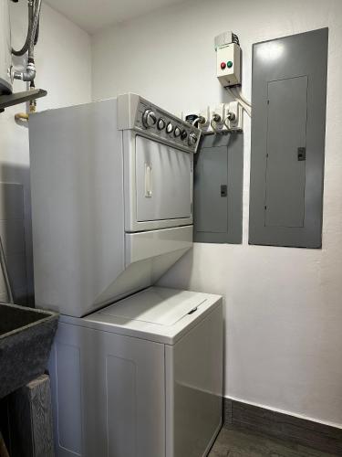 a white kitchen with a stove and a door at AmazINN Places Casa del Mar in Panama City