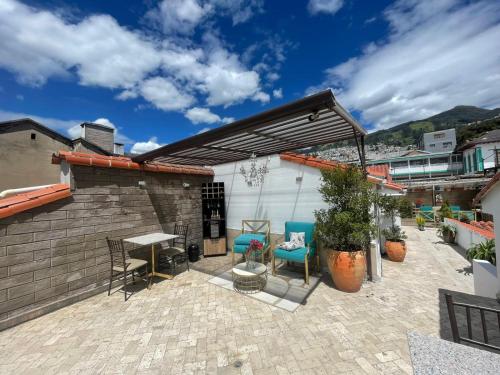 un patio con sillas, una mesa y un edificio en Adamas House Hotel Boutique en Quito
