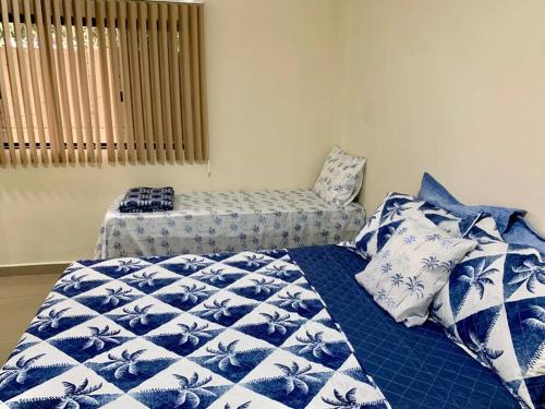 a bedroom with a bed with blue and white sheets at 2 Quartos Completo Barato in Brasilia