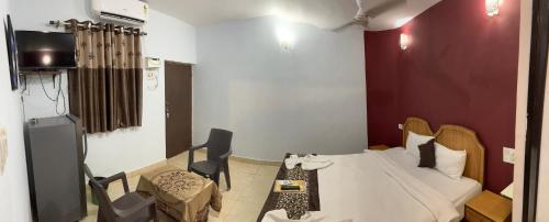a room with a bed and a table and a couch at Hotel Ocean Face, BAGA in Baga