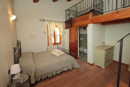 una camera con un grande letto e una scala di Tenuta Le Garzaie - Villa Furlo a Fermignano