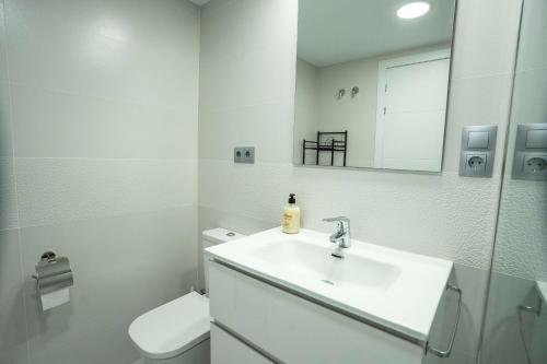 ein weißes Bad mit einem Waschbecken und einem WC in der Unterkunft Cómodo apartamento en Playa Gandia in Los Mártires