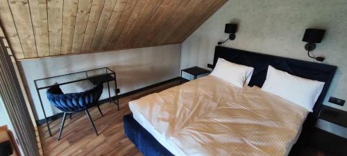 ein Schlafzimmer mit einem Bett, einem Tisch und einem Stuhl in der Unterkunft Loft Point 2 in Marciszów