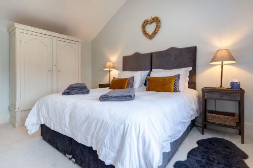 a bedroom with a large white bed with pillows at Heathgate House Apartment in Budleigh Salterton