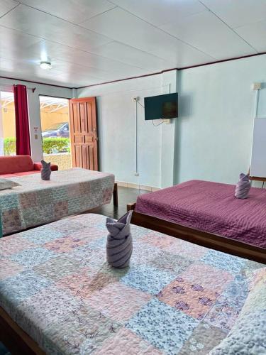 a bedroom with two beds and a vase on the floor at Hotel El Chaman in Uvita