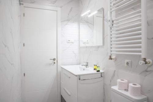 Baño blanco con lavabo y aseo en Apartamento de 4 dormitorios en Retiro, en Madrid