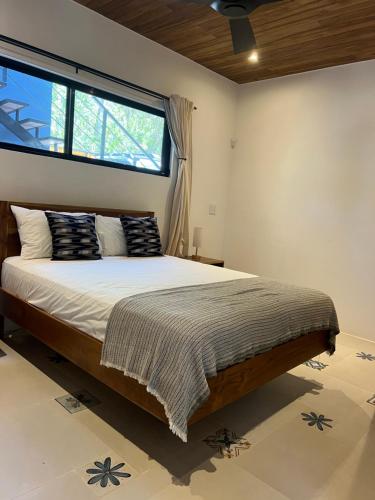 a bedroom with a large bed and a window at Casa Celajes Sol in Nosara