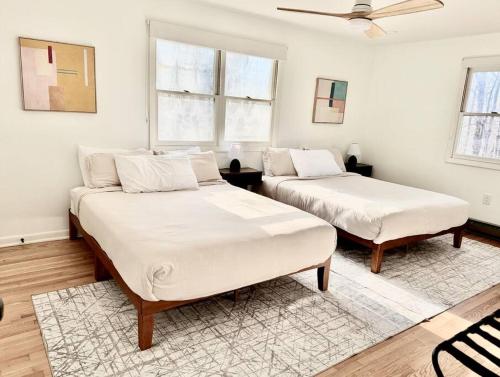 two beds in a room with white walls at Veda Vista - Newly renovated - Rustic Modern Home in Harpers Ferry