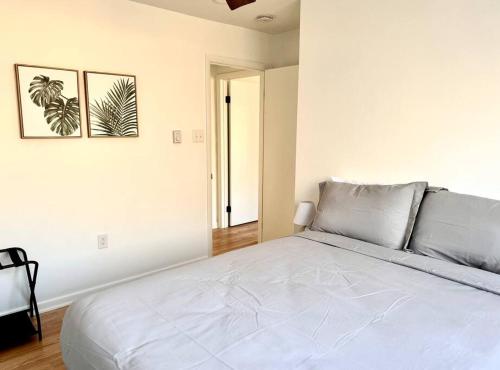 a bedroom with a large white bed with two pictures on the wall at Veda Vista - Newly renovated - Rustic Modern Home in Harpers Ferry