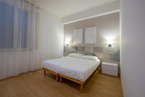 um quarto branco com uma cama e uma janela em Guest House Romano em Roma