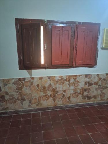 een kamer met 3 rode deuren en een tegelvloer bij Elenas in La Chacarita