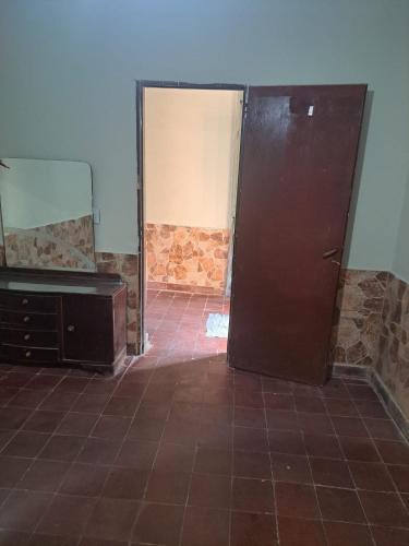 een badkamer met een spiegel, een wastafel en een deur bij Elenas in La Chacarita
