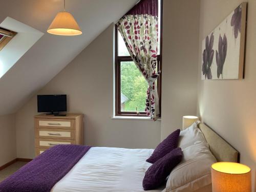 um quarto com uma cama com almofadas roxas e uma janela em Water Mill Vacations Goldfinch - Pet Friendly em Newport