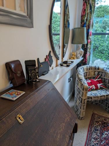 a living room with a wooden table and a mirror at Panoramic sea views, sleeps 4, Torquay in Torquay