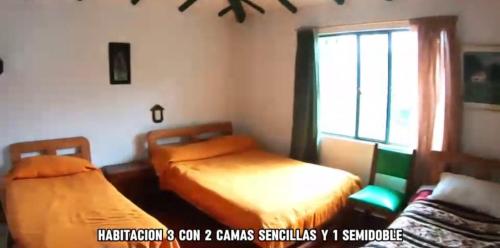 um quarto com 2 camas e uma janela em Finca Hotel em Sutamarchán