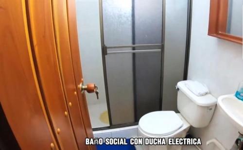 uma casa de banho com um WC e uma cabina de duche em vidro. em Finca Hotel em Sutamarchán